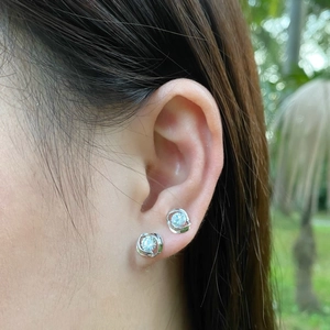 On-ear view of S925 sterling silver swirl stud earrings with round cubic zirconia