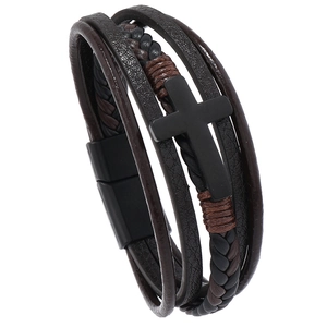 Detail of multi-layer leather bracelet with black metal cross and magnetic clasp