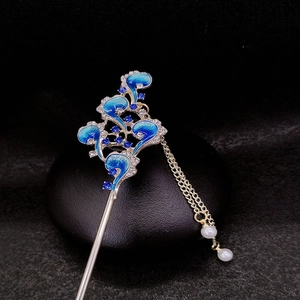 Detail of blue enamel cloud hairpin with silver tassels and pearls on black stone