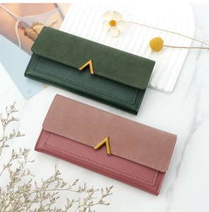 Detail of long PU leather wallets with golden V-shaped metal buckles and snap closure