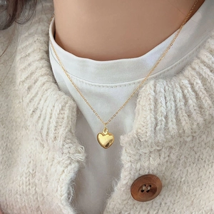Minimalist 925 sterling silver heart necklace in gold finish worn on model