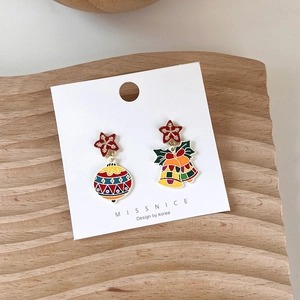 Detail of asymmetric Christmas star earrings with festive bells and colorful baubles