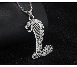 Gros plan du collier avec pendentif cobra argenté hip-hop en acier inoxydable sur fond sombre