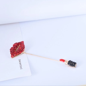 Elegant gold-tone lipstick and red crystal lip brooch with dangling chains and pins