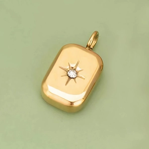 14k gold filled rectangular pendant featuring a starburst engraving and clear zircon