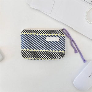 Detail of hand-woven striped cosmetic bag with blue diagonal patterns and purple zipper pull