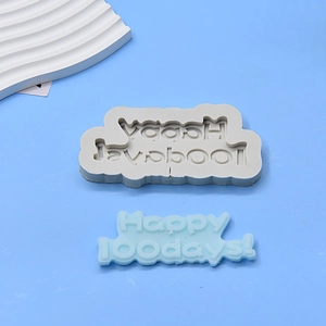 Detailed view of grey silicone mold and blue Happy 100days fondant cake decoration