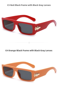 Detail view of red and orange rectangular sunglasses with golden geometric side accents