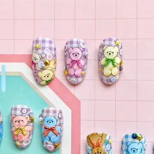 Detail of 3D embossed nail art stickers with cute bears, tulips, and purple grid patterns