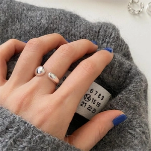 Close-up of a minimalist 925 sterling silver chunky teardrop ring on a knit sweater