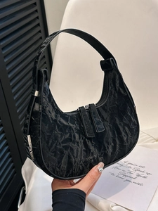 Minimalist black pleated crescent hobo bag with dual zipper shown in a stylish side view