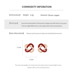 Detail view of 1.1cm gold plated copper earrings with zircon and burgundy enamel accents
