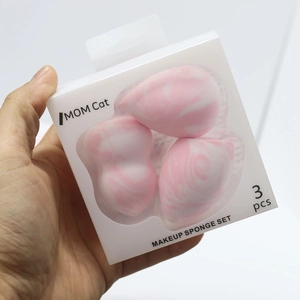 Hand holding a set of 3 marble makeup sponges with waterdrop and teardrop shapes