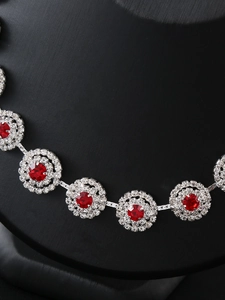 Macro shot of silver bridal necklace with ruby red stones and clear crystal accents