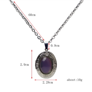 Detail of vintage silver locket with floral relief and purple oval stone on O-chain