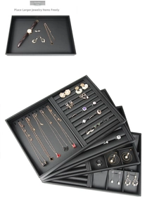 Close-up of black PU jewelry trays with various compartments for rings and necklaces