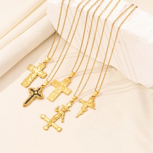 Detailed macro view of 18K gold-plated gothic cross pendants with intricate engravings