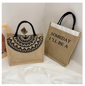 Macro detail of natural jute tote bags with black round handles and geometric ethnic patterns