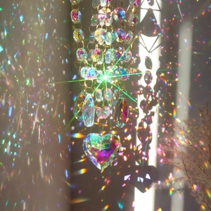 Crystal suncatcher with faceted beads and heart pendant creating rainbow light reflections