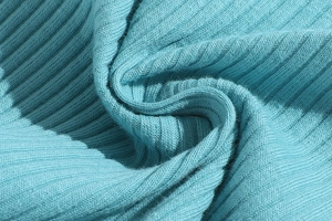 Detailed close-up of blue ribbed knit cotton fabric showing soft texture and fine stitching