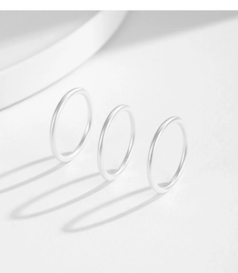 Detailed view of three minimalist S999 silver rings with a matte sandblasted texture