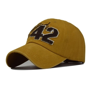 Detail view of mustard yellow cotton baseball cap with number 42 embroidery and fine stitching