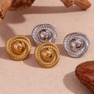 Close-up of vintage round button earrings with twisted texture and mirror finish
