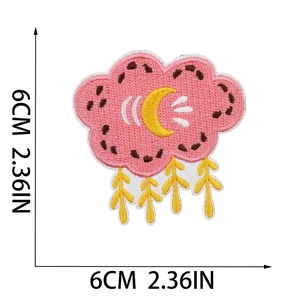 Detail view of 6x6cm pink cloud embroidery patch with yellow moon and tassel accents