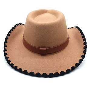Detail of tan western cowboy hat with dark brown leather band and black stitched brim edge