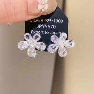 Vue macro de boucles d'oreilles fleur en argent 925 avec zircons et perles