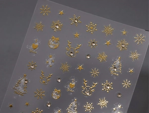 Macro view of gold foil Christmas nail stickers with reindeer patterns and small rhinestones