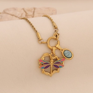 Detailed shot of golden twisted chain necklace with dragonfly pendant and turquoise stone
