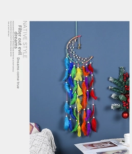 Detalle de plumas arcoíris y estrella dorada en atrapasueños con forma de luna