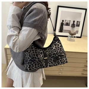 Detail der Hobo-Tasche mit Leopardenmuster, Lederriemen und goldener Schnalle am Model