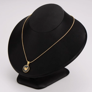 Golden snake chain necklace featuring a round black shell pendant with butterfly design