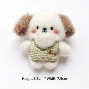 Detailed view of 8.5x7.5cm white plush dog charm wearing a green striped knit vest