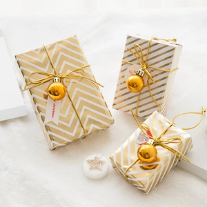 Three-piece gold and white Christmas gift box set with striped patterns and festive ornaments