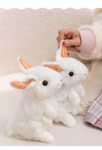 Close-up of soft white plush bunny toys showing realistic long fur and pink inner ears