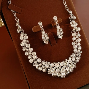 Detailed view of silver jewelry set with geometric crystals on velvet stand
