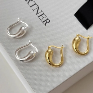 Close-up of S925 sterling silver stamp on U-shaped teardrop earrings in gold and silver