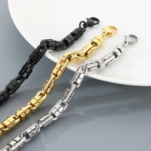 Detailed close-up of stainless steel chain bracelets in black, gold, and silver finishes