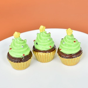 Detailed view of three resin green Christmas tree cupcake figurines on a white plate