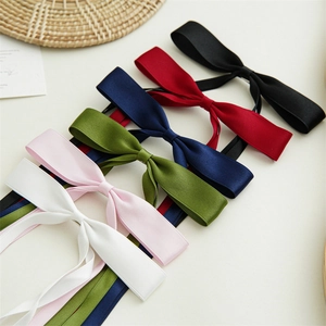 Detail of colorful satin bow hair clips with long ribbons in multiple elegant colors