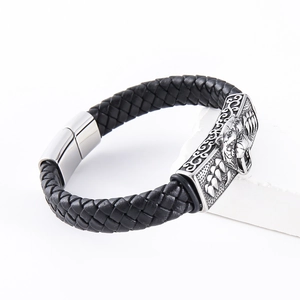 Men's leather braided bracelet with silver lion head clasp on stone display