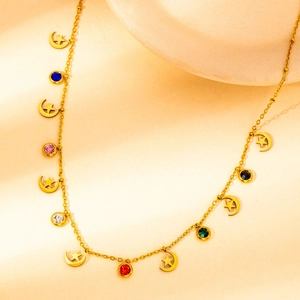 Detail of gold star and moon necklace with colorful zircon stones on art display