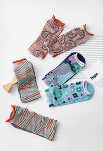 Detailed view of patterned sheer glass silk socks with rolled cuffs and geometric motifs