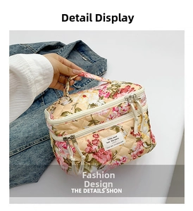 Detail of floral quilted cosmetic bag featuring double zipper closure and top handle