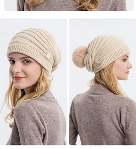 Détail d'un bonnet en maille beige avec pompon en fourrure et boutons latéraux