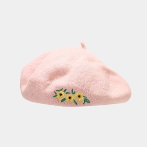 Detail of pink wool beret with handcrafted sunflower embroidery and soft wool texture