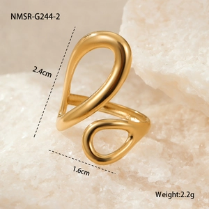 Detail of 18k gold plated open ring with pear shape ends on a white crystal rock